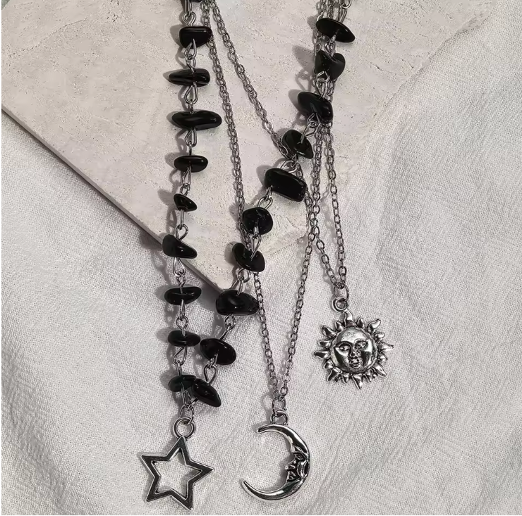 Celestial silver-tone necklace laid on textured cream linen