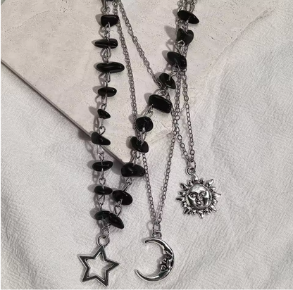 Celestial silver-tone necklace laid on textured cream linen
