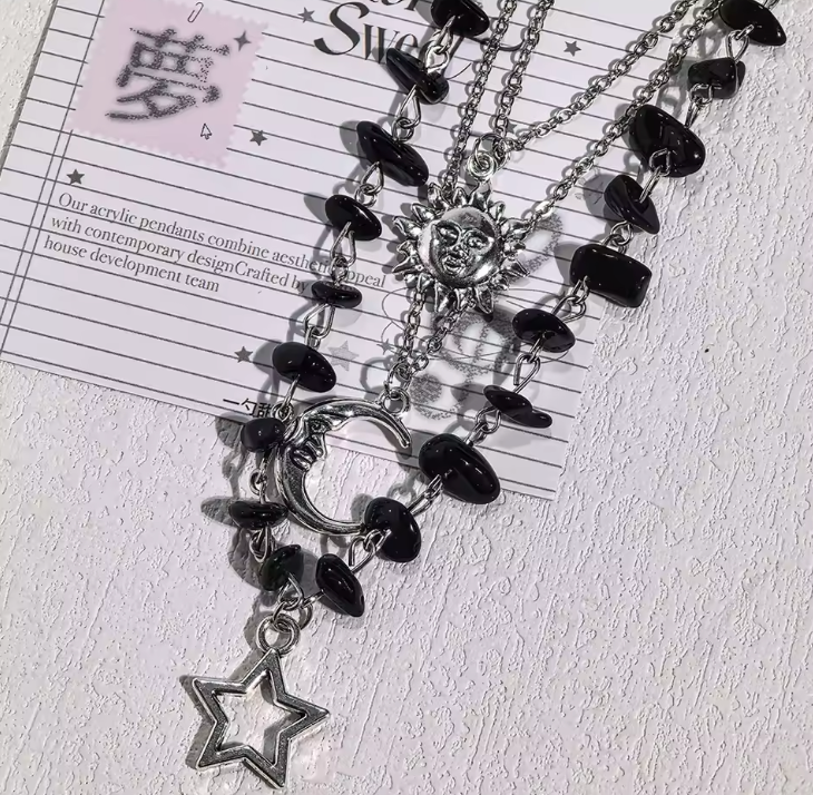Close-up silver-tone sun moon and star charms with black chip beads
