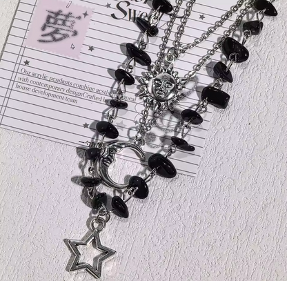 Close-up silver-tone sun moon and star charms with black chip beads