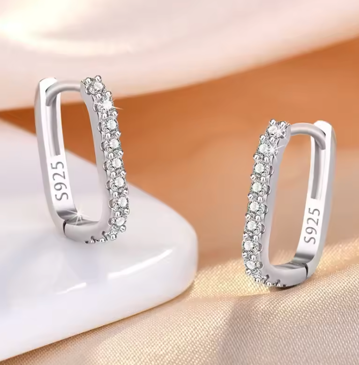 Silver tone earrings styled on satin