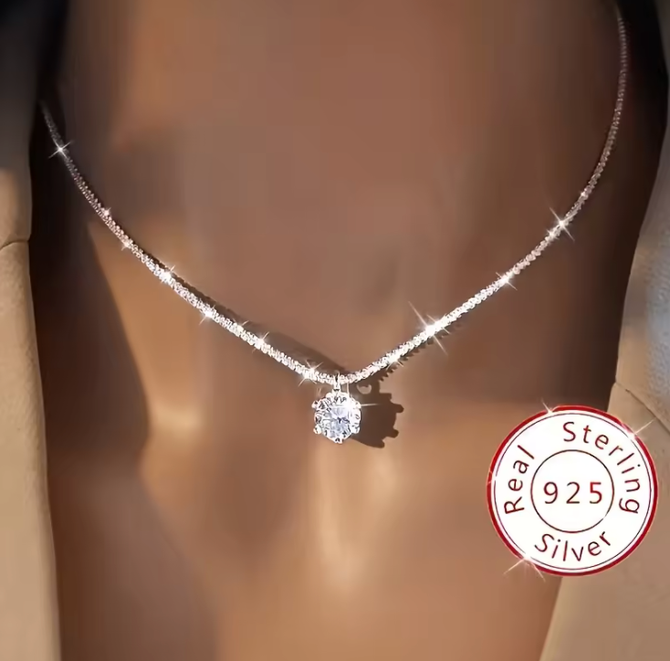 Solitaire pendant necklace worn against dark neckline