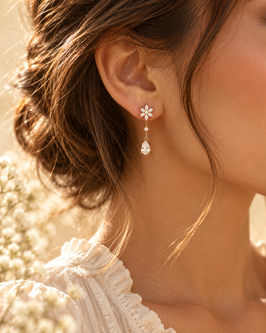 Gold-tone crystal drop earring worn in golden sunlight