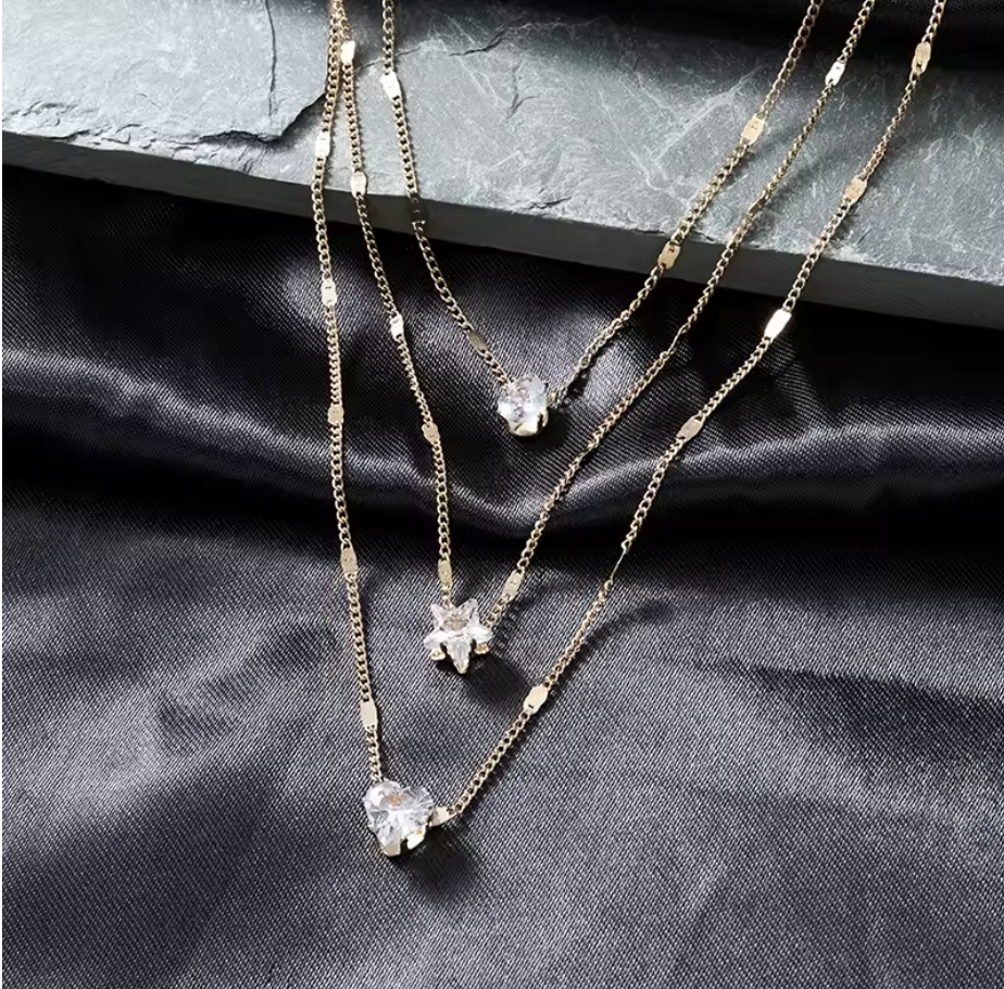 Trinity Three-Charm Layered Necklace detail on black satin