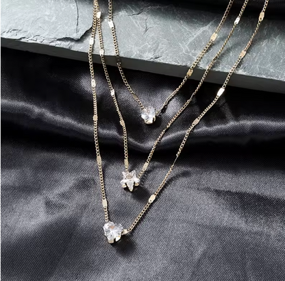 Trinity Three-Charm Layered Necklace detail on black satin